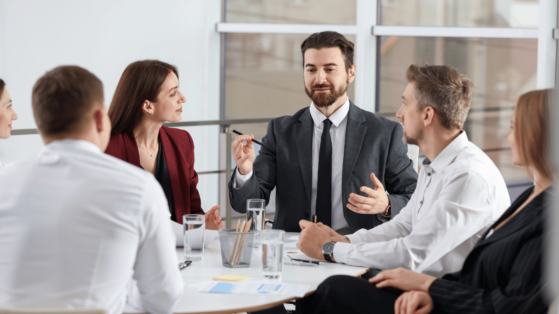 Business professionals discussing plans with an adviser in a meeting